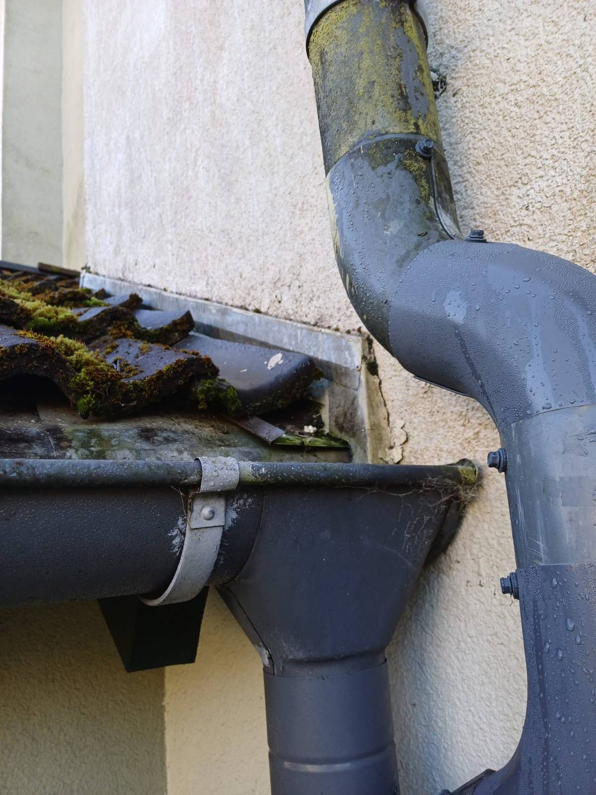 Stara, nieprawidłowo zamontowana rura spustowa i stara rynna